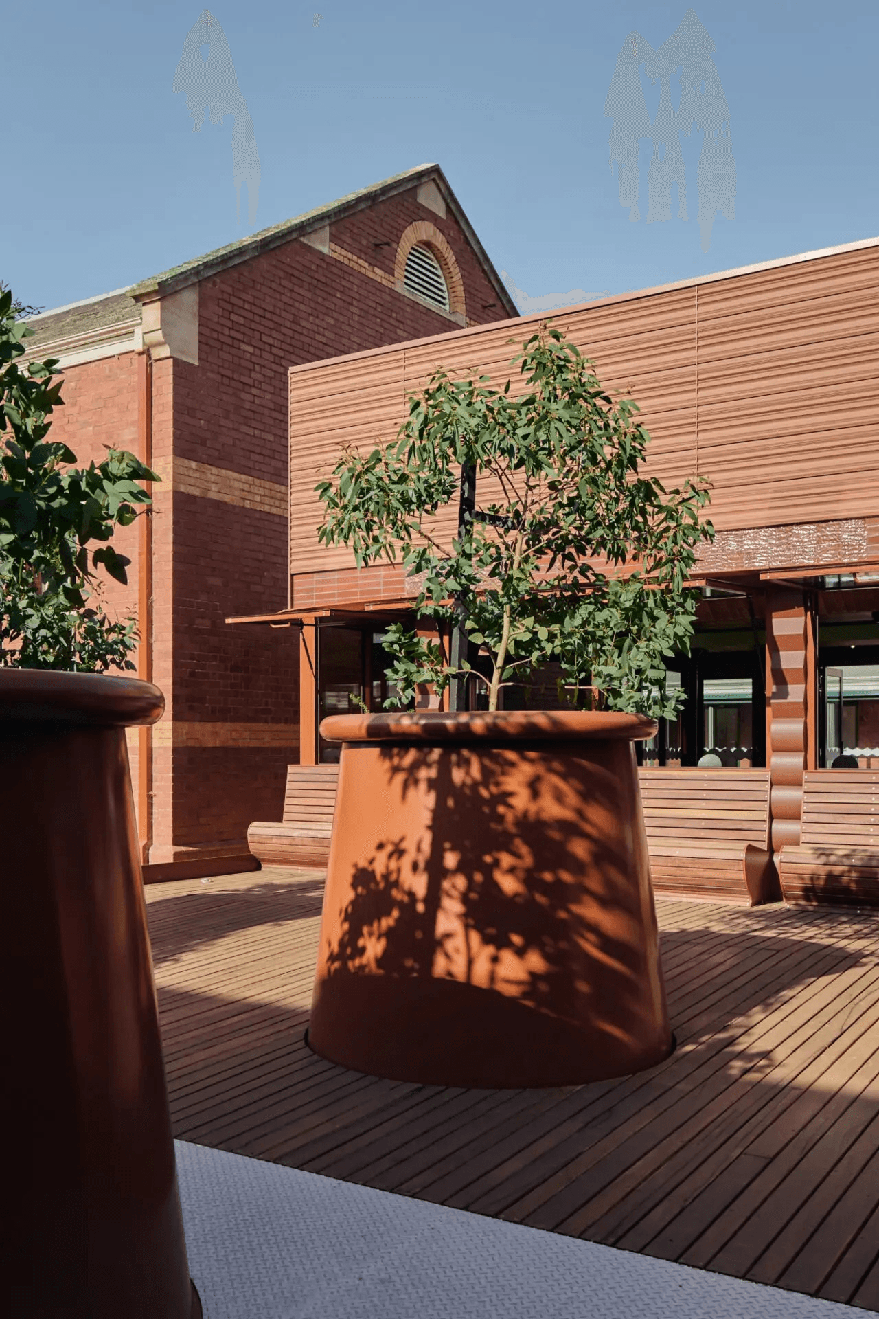 Potted tree in red brick and wooden courtyard
